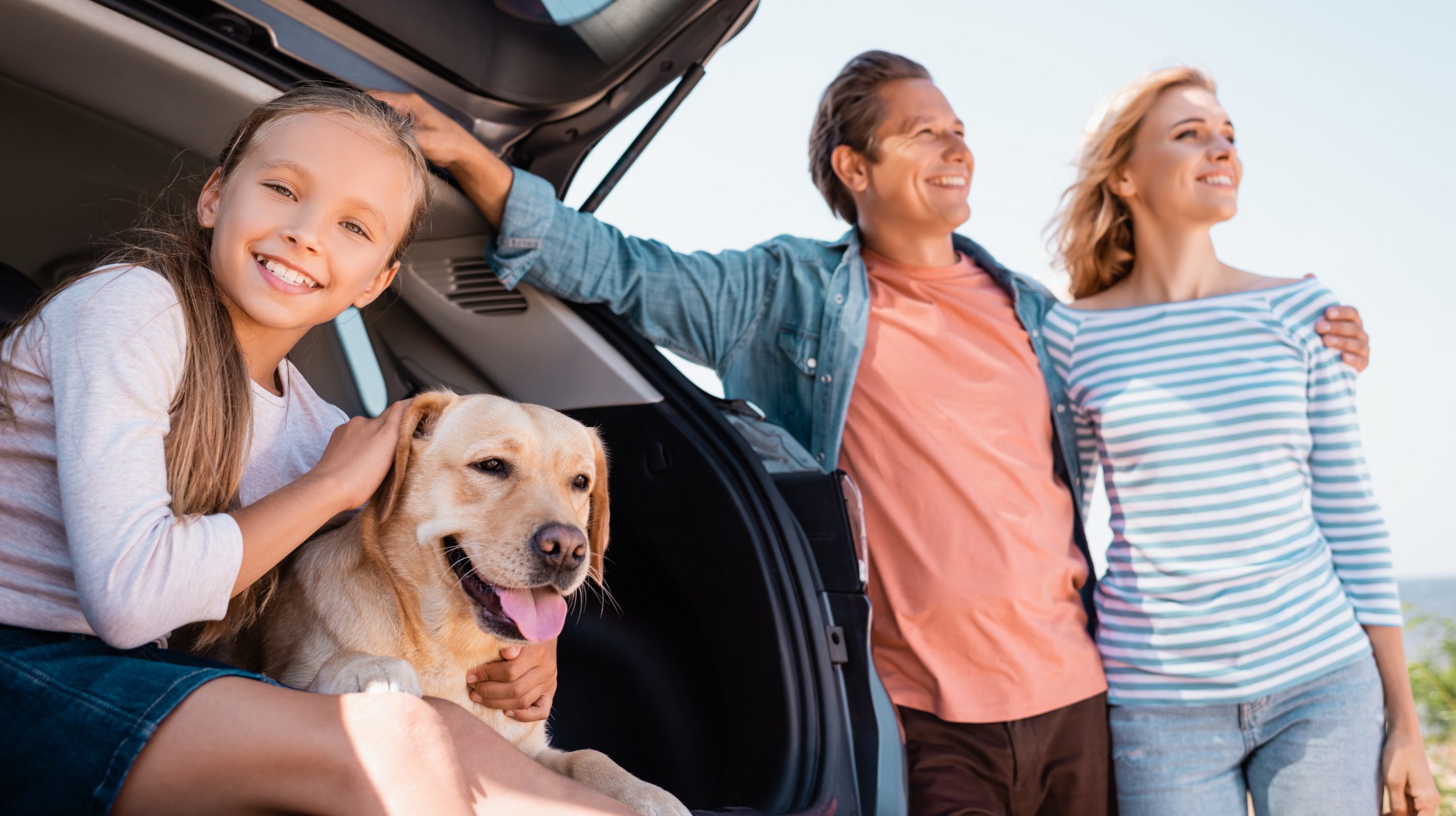 Family near car with dog